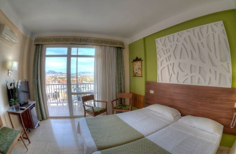 a hotel room with two beds and a large window