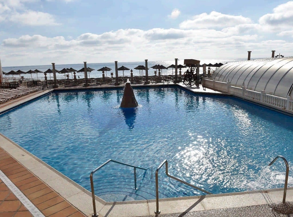 a large swimming pool with a fountain in the middle