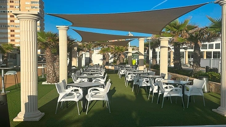 a restaurant with tables and chairs under umbrellas