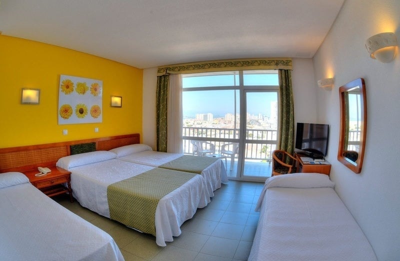 a hotel room with three beds and a large window