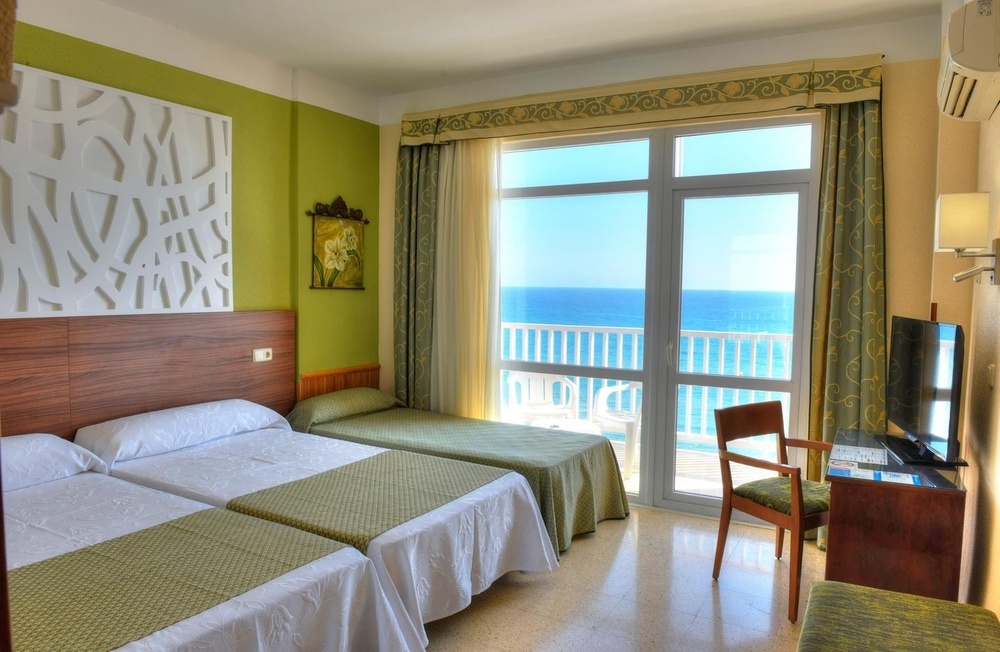 una habitación de hotel con una cama y vistas al mar