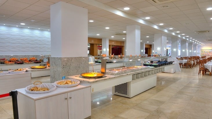 a buffet in a restaurant with a basket of potatoes on the counter