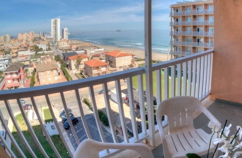 a balcony with a view of the ocean and buildings