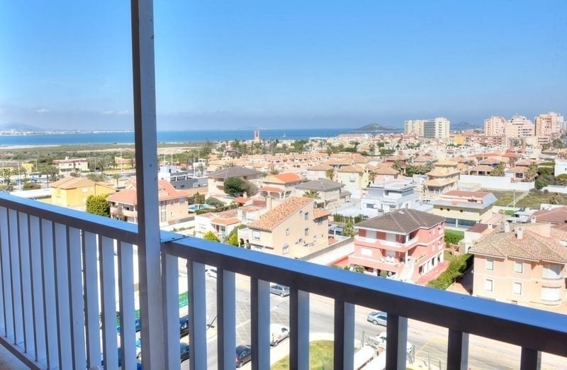 a balcony with a view of a city and the ocean