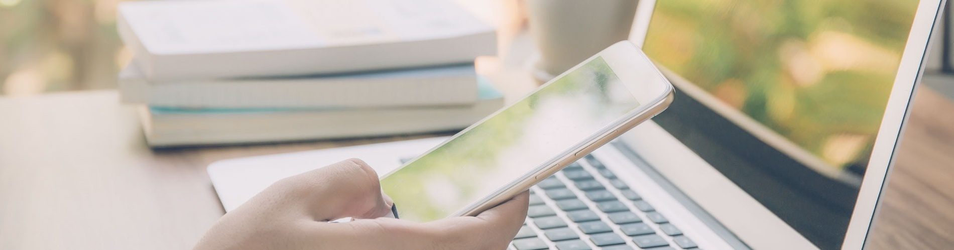 une personne tient un téléphone portable à côté d' un ordinateur portable