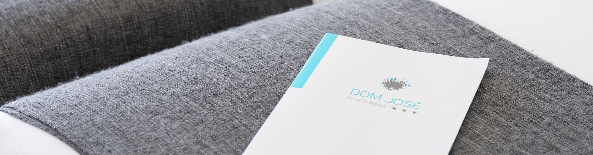 une brochure de l' hôtel dom jose est posée sur une couverture grise