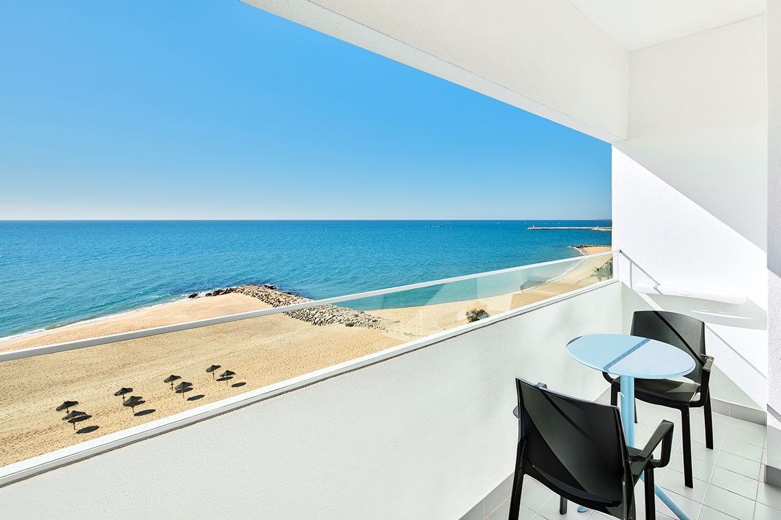 uma varanda com mesa e cadeiras com vista para o oceano