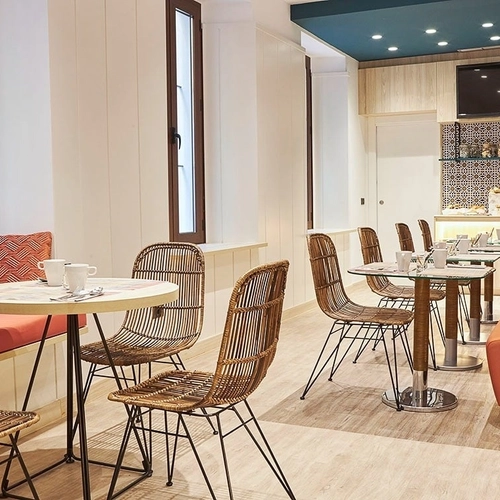 Espacio acogedor para desayuno con mesas de ratán y cómodos asientos. U-Sense Sevilla Centro