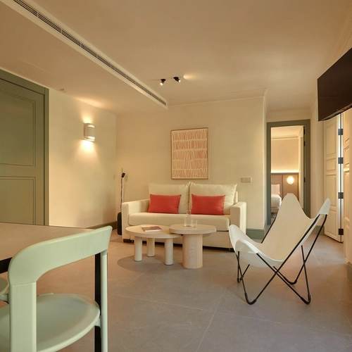 Sala de estar elegante con sofá, sillón mariposa y mesa de centro en hotel boutique. U-Sense Granada Gran Vía