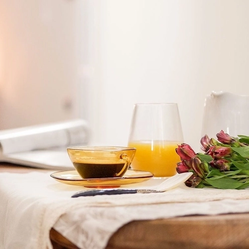 Desayuno tranquilo: café, jugo de naranja, flores y revista en mesa. U-Sense Sevilla Catedral