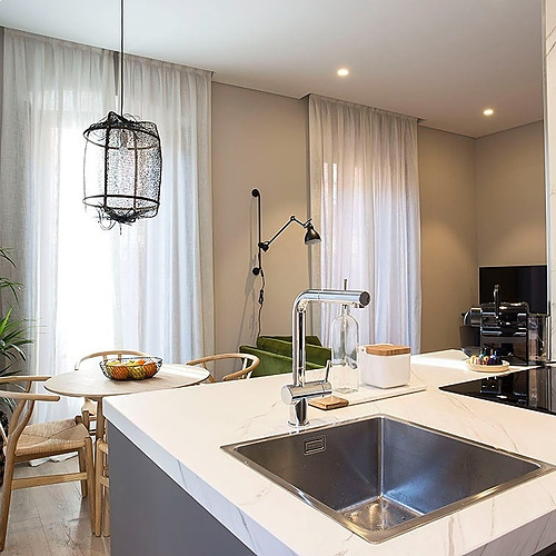 Cocina moderna con encimera de mármol, lavabo y vitrocerámica. U-Sense Granada Catedral