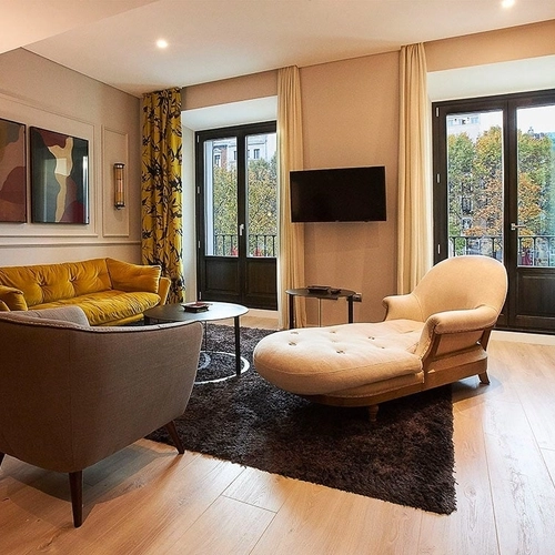 Estancia de lujo: Sofá amarillo, chaise longue y arte moderno. U-Sense Madrid Santa Ana