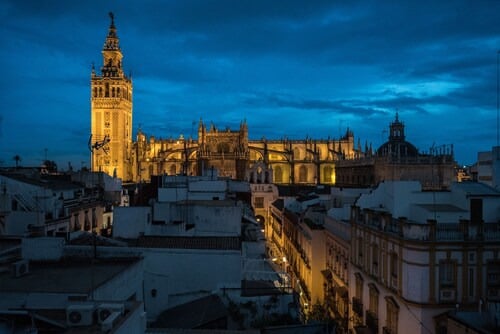 La Giralda iluminada sobre la ciudad de Sevilla. U-Sense Sevilla Santa Cruz | Apartamentos Turísticos en Sevilla