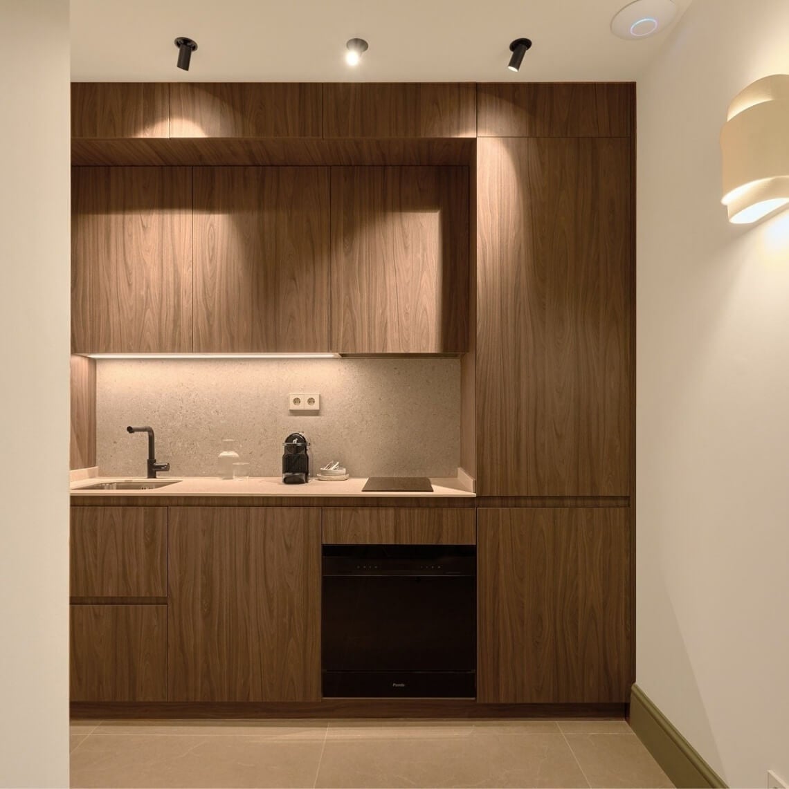 Modern kitchen with wooden cabinets, grey countertops, and integrated appliances. U-Sense
