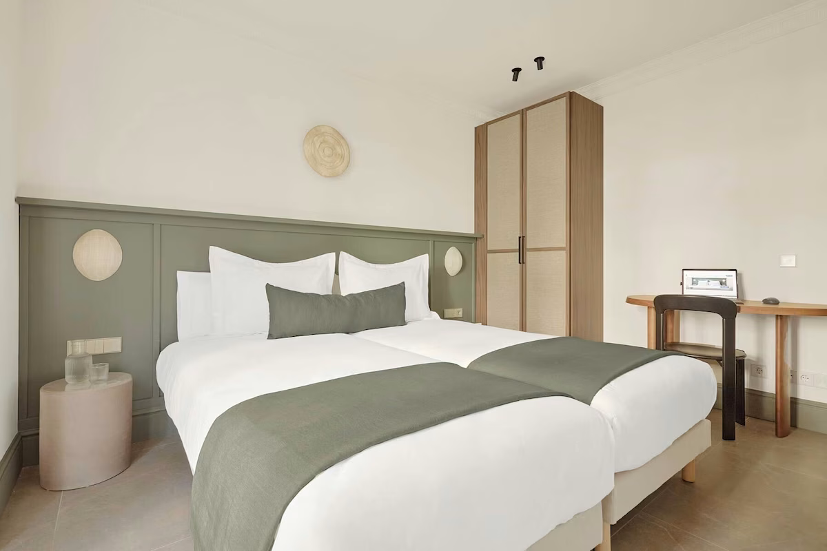 Room with two beds, wardrobe and desk. U-Sense Sevilla Santa Cruz