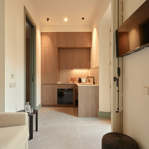Cocina moderna y cómoda en habitación de hotel con acabados en madera. U-Sense Granada Gran Vía