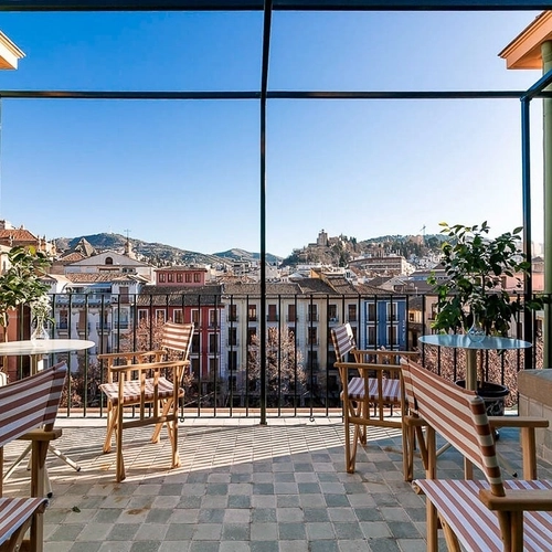 Terraza con vistas a la ciudad, muebles de exterior y luz natural. U-Sense Granada Centro