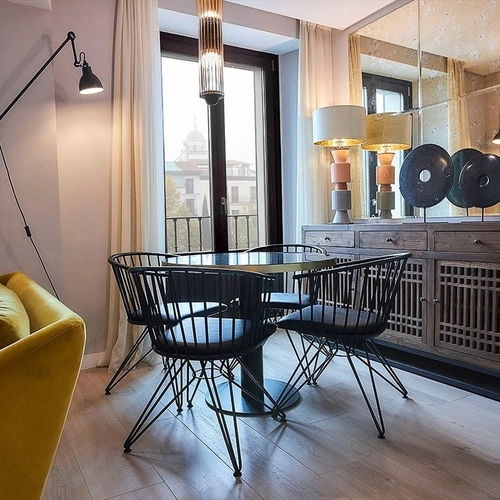 Comedor elegante con sofá amarillo y cubertería. U-Sense Madrid Santa Ana