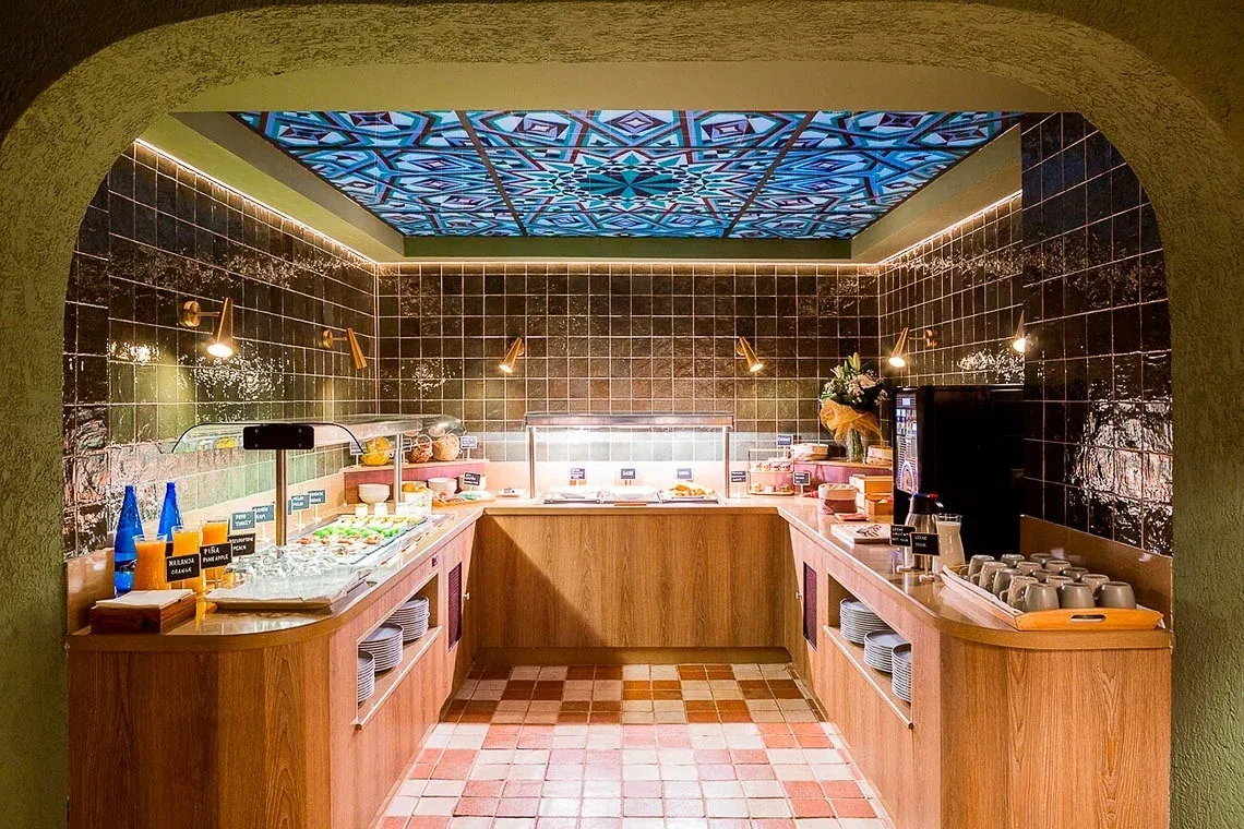 Hotel buffet with green tiles and vibrant decor. U-Sense