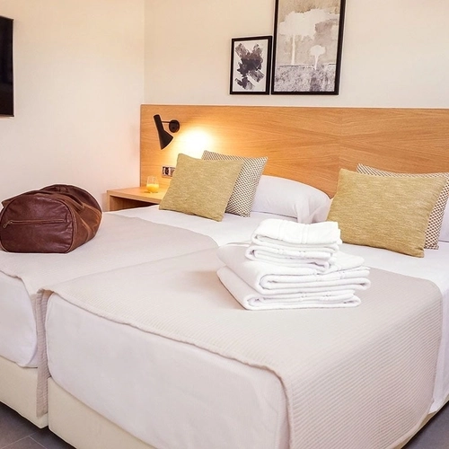 Cómoda habitación doble con dos camas, TV de pantalla plana y decoración moderna. U-Sense Sevilla Catedral