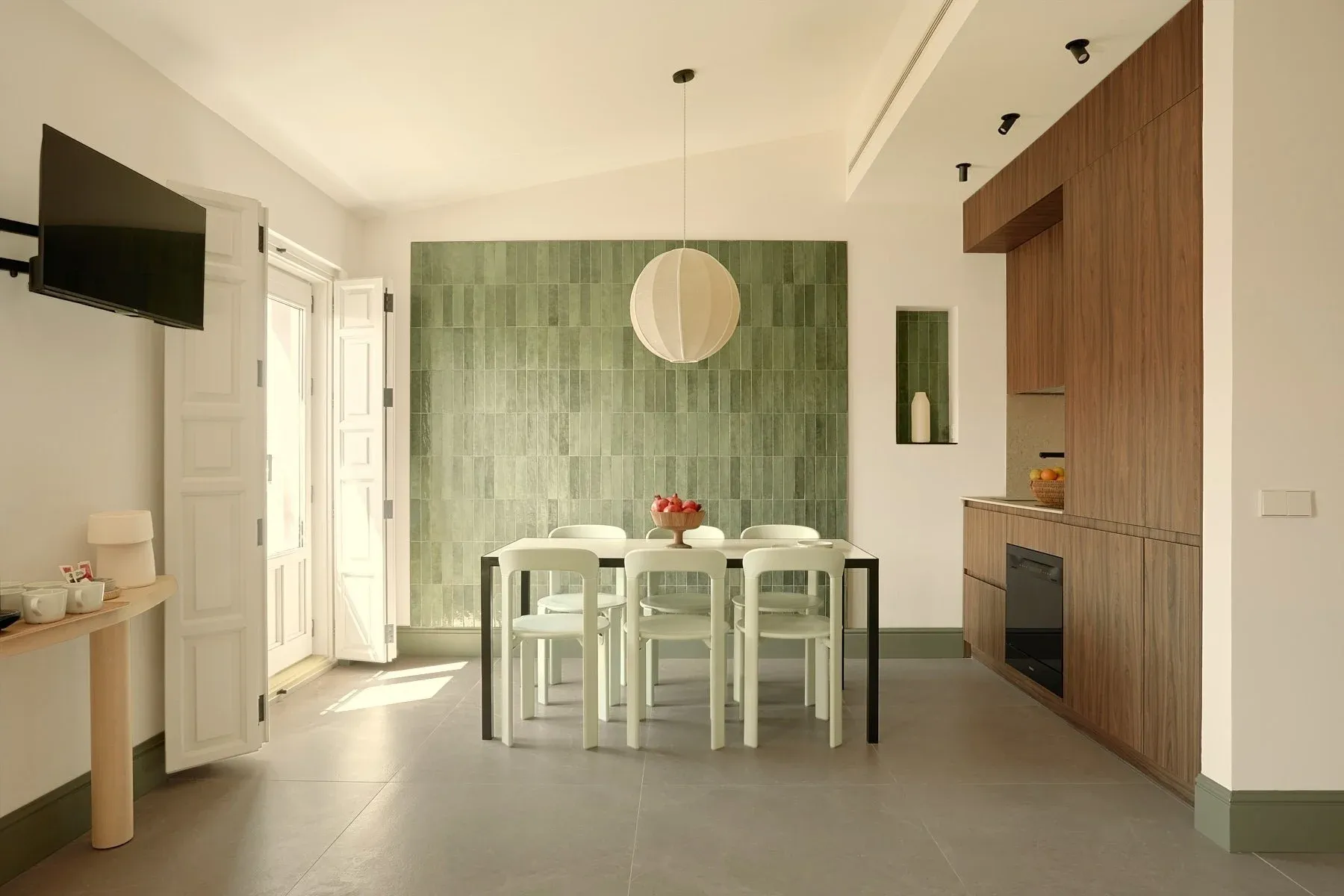 Elegant dining room and kitchen with green tiles and breakfast bar. U-Sense Granada Gran Vía