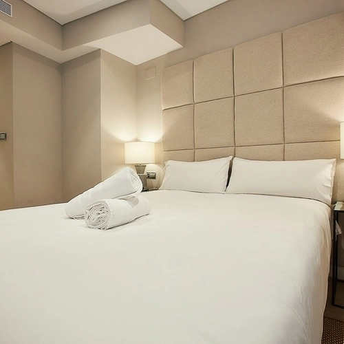 Habitación de hotel con cama grande, cabecero acolchado y lámparas de noche. U-Sense Madrid Santa Ana