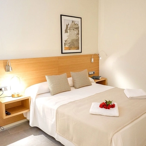 Cama confortable, mesitas de noche y cuadro decorativo. U-Sense Sevilla Catedral
