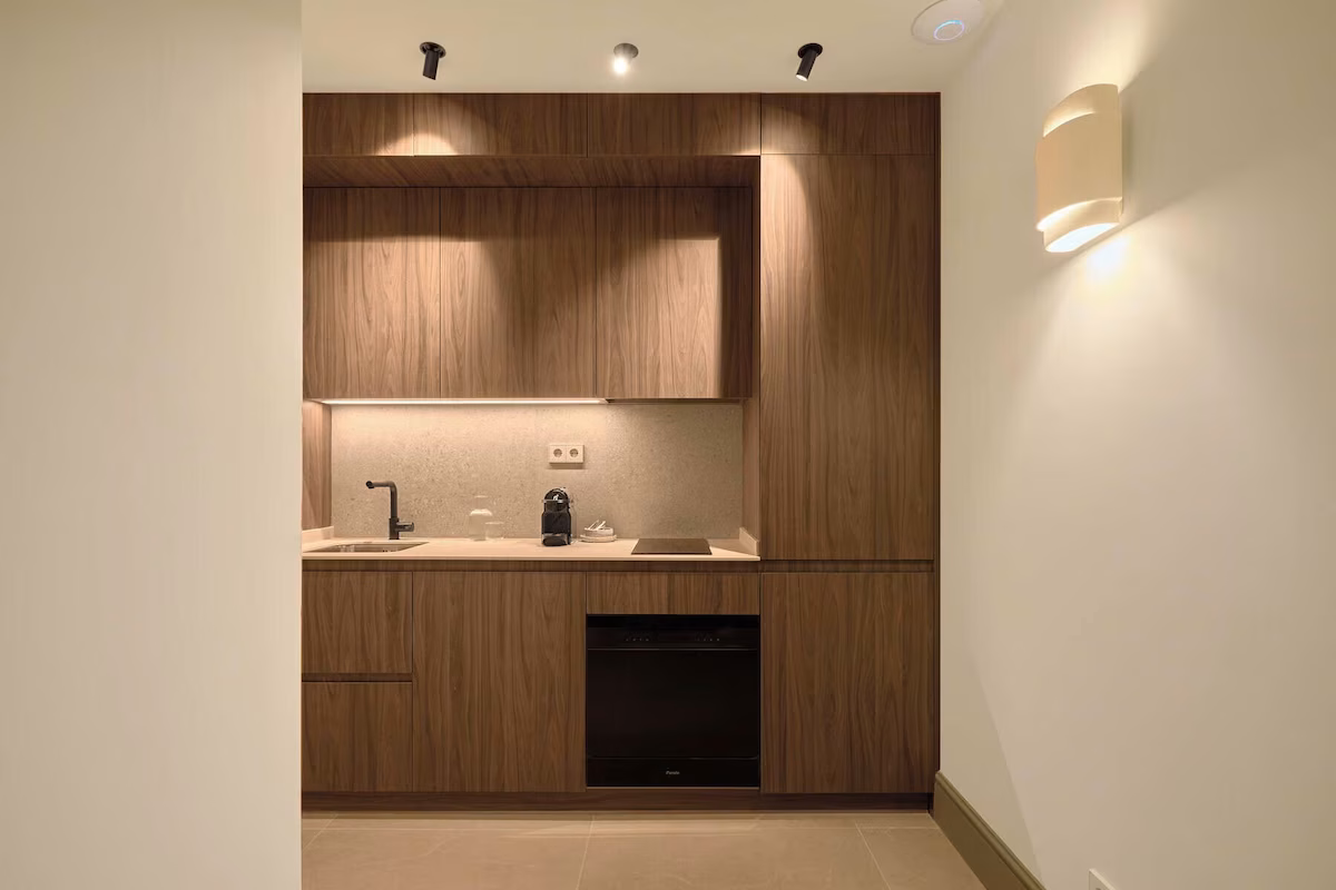 Modern walnut kitchenette with under-cabinet lighting and U-Sense.