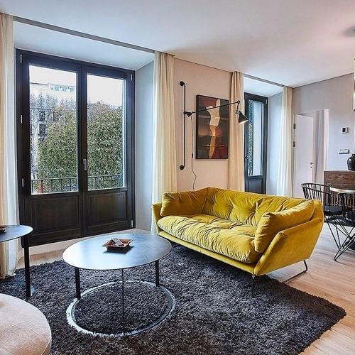 Sofá amarillo y mesa de centro en sala de estar de hotel moderno. U-Sense Madrid Santa Ana