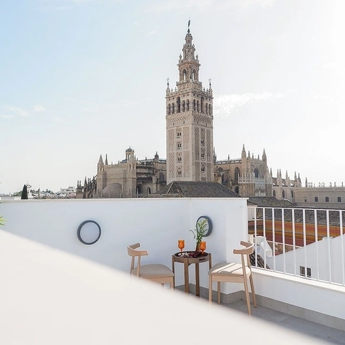 Terraza con vistas a la Catedral, dos sillas y mesa. U-Sense Sevilla Catedral