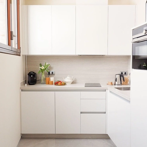 Cocina moderna y luminosa con electrodomésticos blancos y detalles elegantes. U-Sense Sevilla Catedral