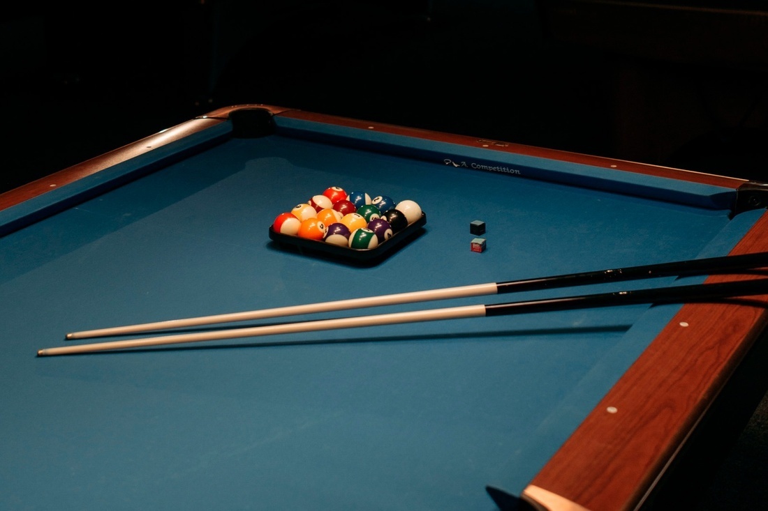 una mesa de billar con un juego de bolas y palos