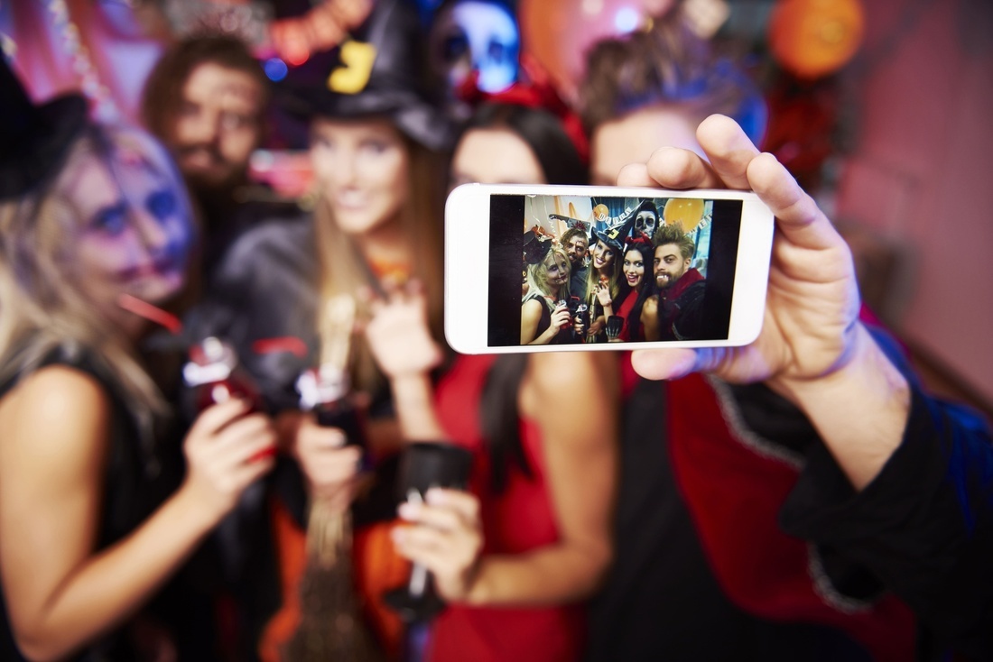 a man is taking a picture of a group of people at a halloween party