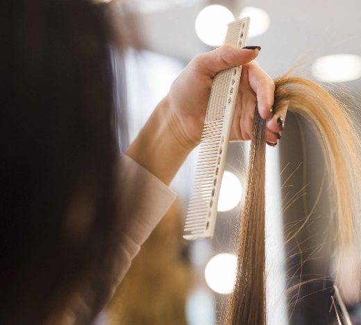 une femme se peigne les cheveux avec un peigne blanc