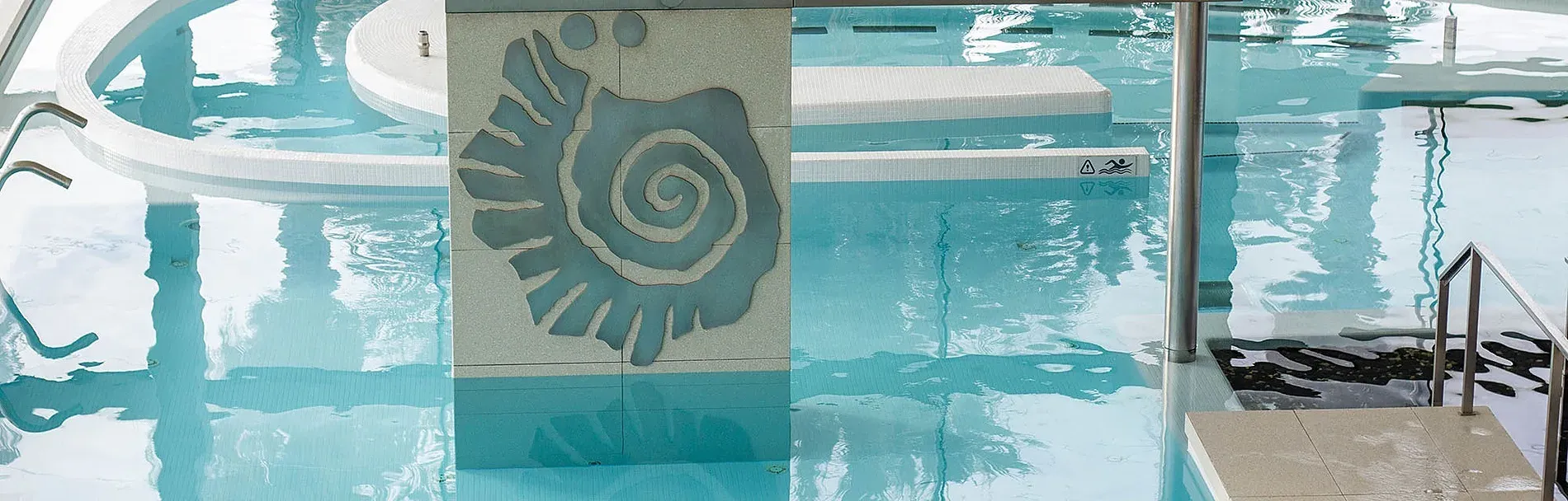 ESTIVAL: Aquum Spa, piscina amb escales interiors i detall d'escultura de caracola.