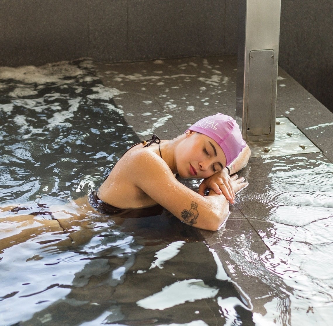 une femme plonge dans une piscine sur le toit d' un bâtiment