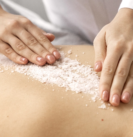 une femme applique du sel sur le dos d' une autre femme