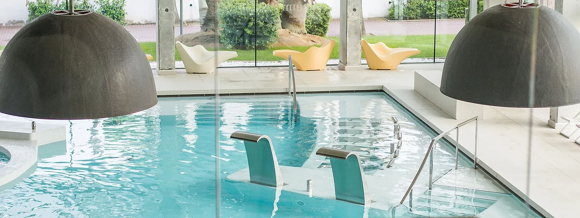 Instalaciones | Piscina moderna con cascadas y tumbonas en Aquum Spa & Wellness, Tarragona.
