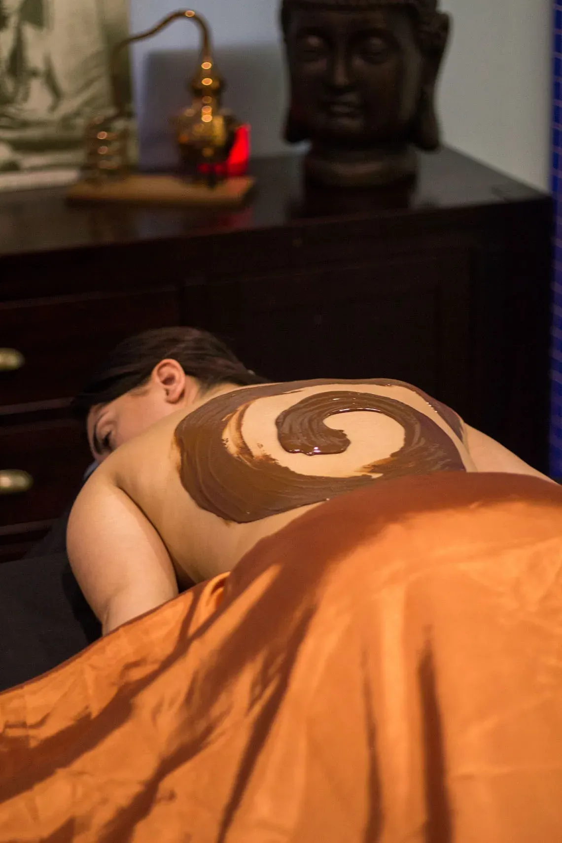 una mulher está recebendo um massagem de chocolate e mel .