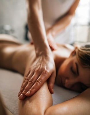 une femme reçoit un massage du visage avec ses yeux fermés