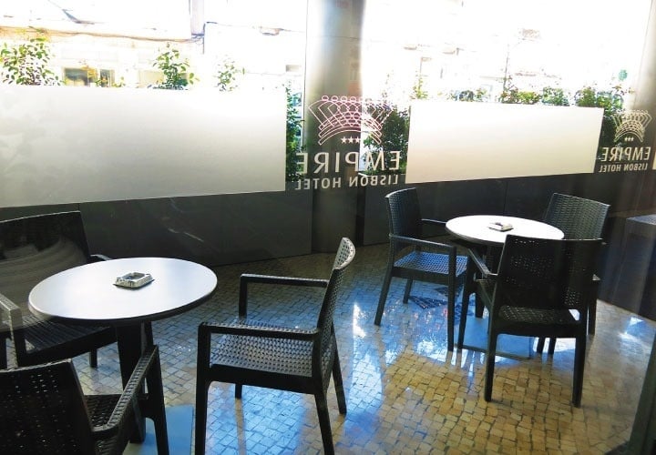 tables and chairs in front of a wall that says empire hotel