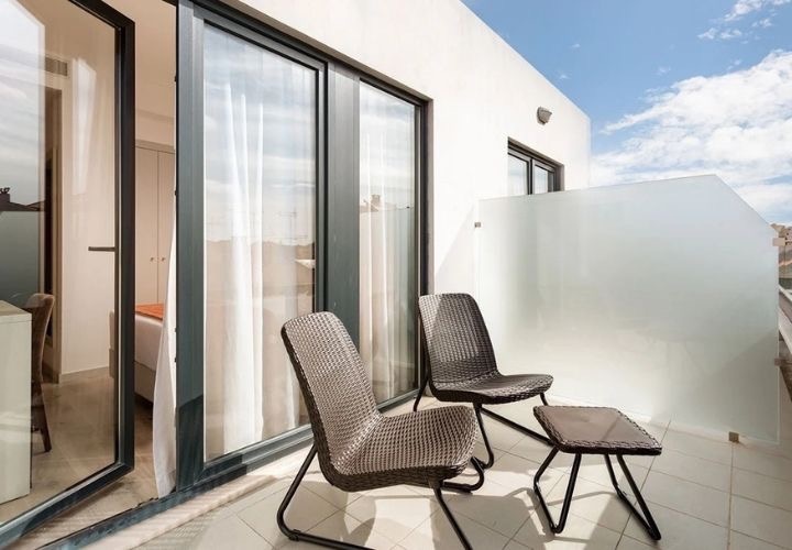 a balcony with two chairs and a small table