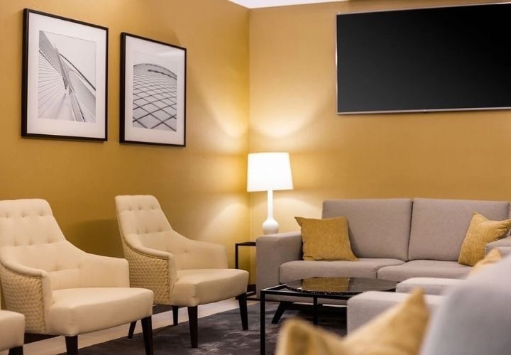 a living room with a couch and chairs and a flat screen tv