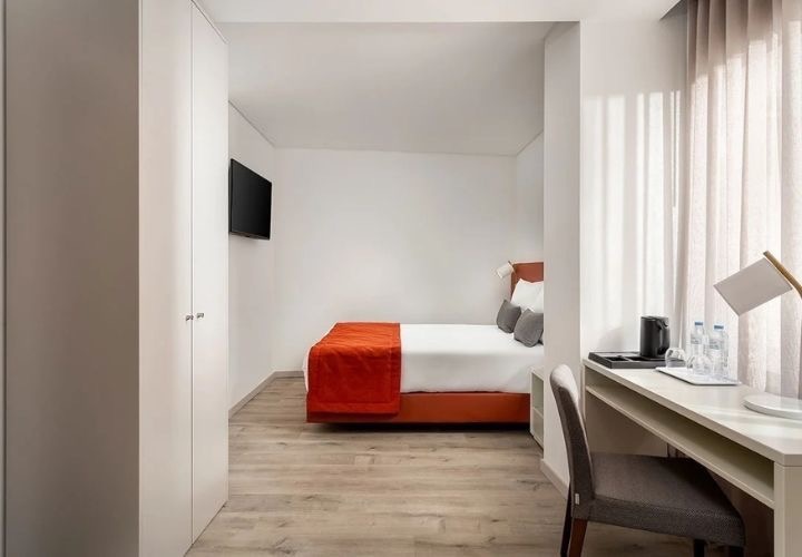 a hotel room with a king size bed and a desk