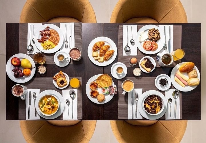 a table topped with plates of food including croissants