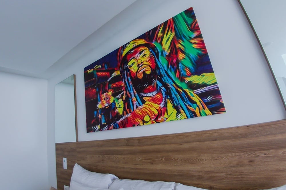uma pintura colorida de um homem com dreadlocks está pendurada na parede