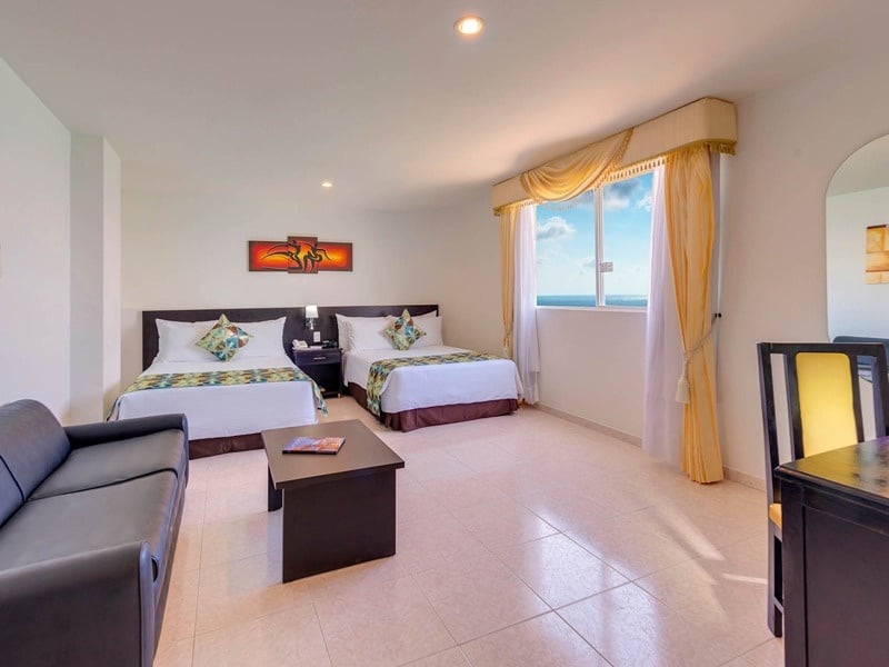 um quarto de hotel com duas camas e uma mesa
