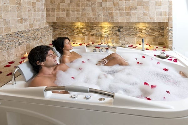 un hombre y una mujer se relajan en una bañera llena de espuma