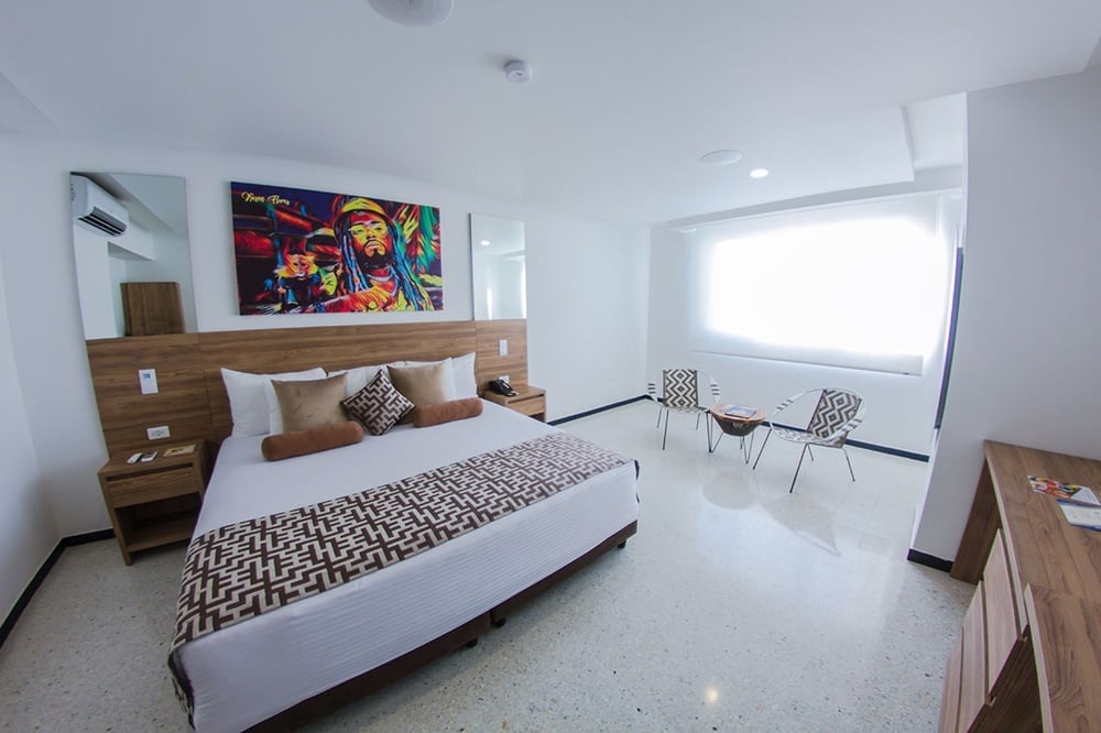 um quarto de hotel com uma pintura de bob marley na parede