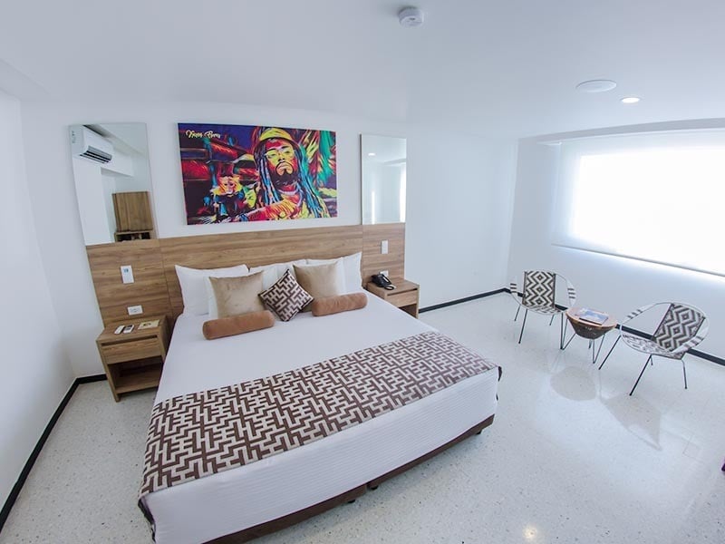 um quarto de hotel com uma pintura de bob marley na parede